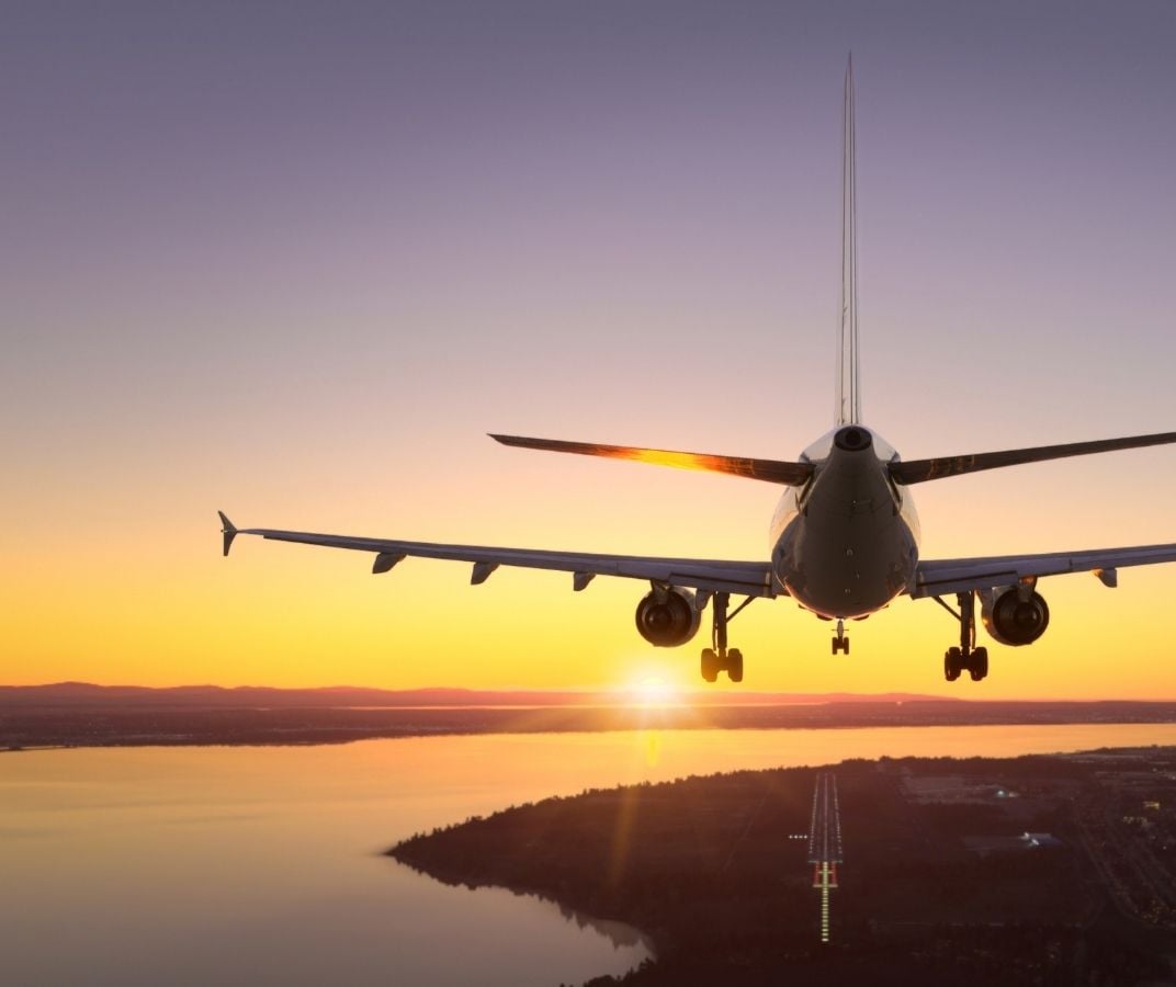Avion de ligne en approche d&rsquo;un a&eacute;roport au coucher du soleil.