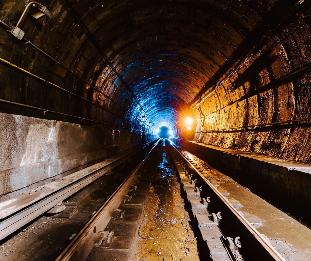 Tunnel souterrain avec voies ferrées dans une mine.